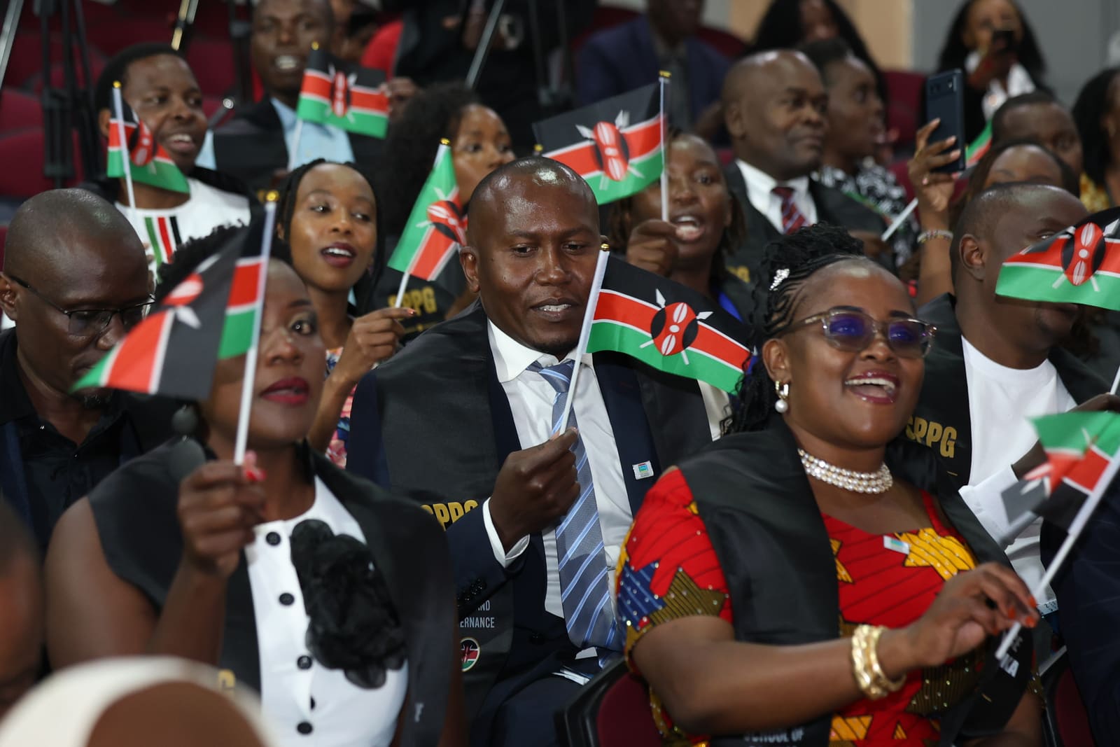 The SPPG Kenya cohort waving Kenyan flags at graduation in Nairobi